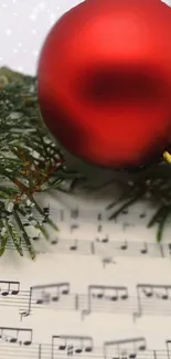 Festive red ornament with sheet music and greenery.