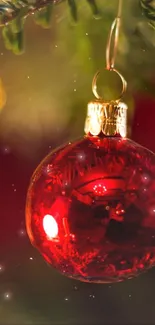 Red Christmas ornament hanging with blurred festive background.