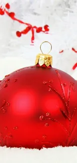 Red Christmas ornament with snowy background.