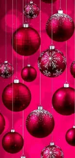 Red Christmas ornaments on a pink background.