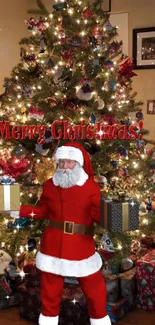 Santa with gifts in front of a lit Christmas tree.