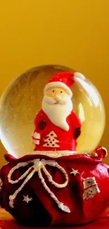 Santa snow globe with yellow backdrop and red base design.