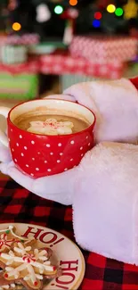 Santa holding red mug with cocoa and cookies on plate.