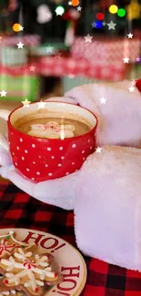 Santa holding a festive mug in front of a Christmas tree.