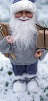 Santa figure in snow with gifts and a sled in a winter scene.