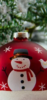 Red Christmas ornament with snowman design.