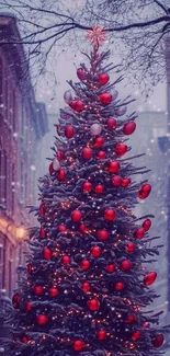 Snow-covered Christmas tree with red ornaments on a city street.