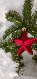 Red star ornament on snowy pine branches, festive mobile wallpaper.