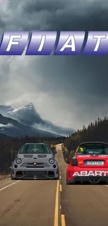 Two Fiat cars on a scenic mountain road with a cloudy sky backdrop.