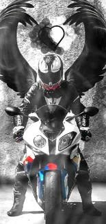 Biker with black wings on a motorcycle against a gray wall.