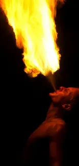 Mobile wallpaper of a firebreather exhaling vibrant orange flames.