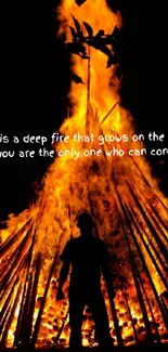 Silhouette stands before a blazing bonfire at night, with an inspirational quote.