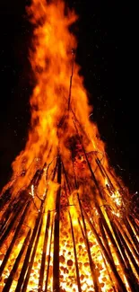 Bright bonfire image with vibrant orange flames against a dark background.