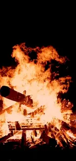 Vivid flames of a bonfire illuminating the night sky, perfect for a cozy mobile wallpaper.