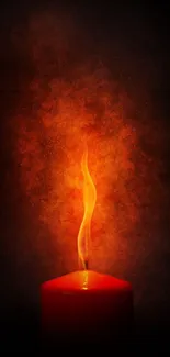 Red candle with a fiery orange flame against a dark background.