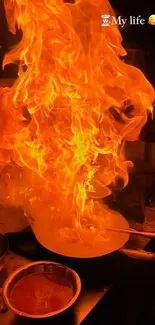 A dramatic flare of flames in a cooking pan in the kitchen.