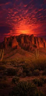 Dramatic fiery desert sunset over mountain with vivid red and purple sky.