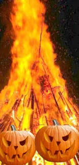 Fiery Halloween bonfire with pumpkin faces.