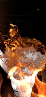 Light bulb engulfed in realistic flames on black background.