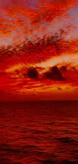 Fiery ocean sunset with red sky reflected on calm waters.