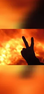 Silhouette peace sign against an orange fiery background.