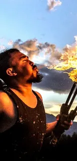 Man performing fire breathing at night with a dramatic sky.