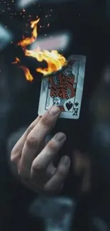 A playing card with flames in sharp focus against a dark background.