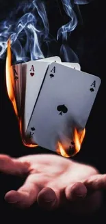 Burning playing cards floating over a hand, creating a magical visual effect.