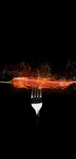 Fiery red chili pepper on fork with flames on a black background.