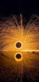 Fiery sparks reflected in water on a dark night.