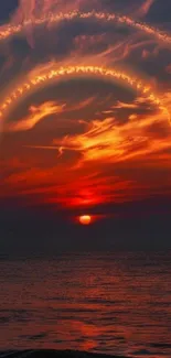 Fiery sunset over ocean with vibrant red clouds.