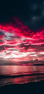 Dramatic sunset with red clouds over ocean horizon.