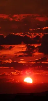 Crimson sunset with dramatic red clouds over skyline.