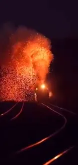 Train emitting fiery sparks on dark tracks.