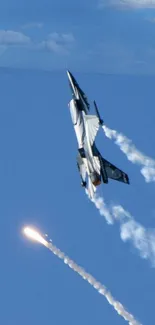 Fighter jet in clear blue sky with vapor trails.