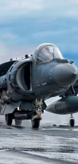 Fighter jet taking off from aircraft carrier with blue sky backdrop.