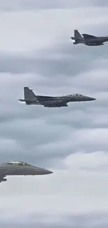 Fighter jets flying through cloudy skies on mobile wallpaper.