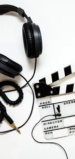 Minimalist wallpaper with headphones and clapperboard on white background.