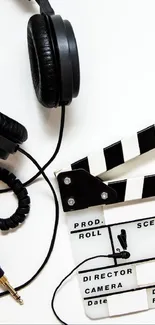 Headphones and clapperboard on white background.