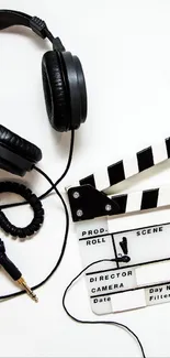Headphones and clapperboard on white background.