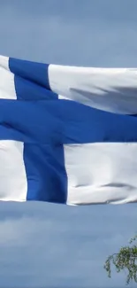 Finnish flag waving under a clear blue sky.