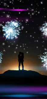 Silhouette of a couple with fireworks in a night sky.