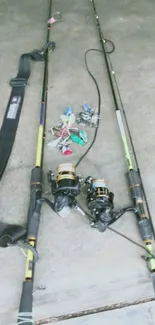 Fishing rods with reels and lures on concrete surface.