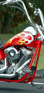 Red motorcycle with flame design parked outdoors.