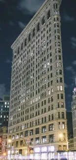 Night view of New York's Flatiron Building with city lights.