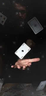 Floating playing cards with a magical hand on dark background.