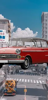 Classic red car floating over a city street with modern buildings.