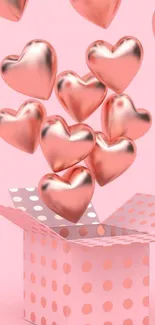 Pink wallpaper with rose gold hearts floating from a dot-patterned gift box.