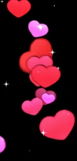 Mobile wallpaper with floating red and pink hearts on a black background.