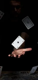 Hand extending with floating playing cards.